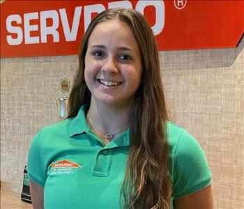 A young lady with long brown hair, wearing a SERVPRO shirt
