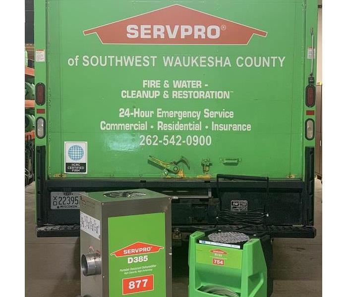 Two types of dehumidifiers in front of SERVPRO work truck