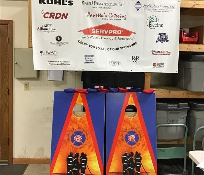 A banner with several sponsor's logos and a set of bags board with the National Fallen Firefighter Foundations logo on them
