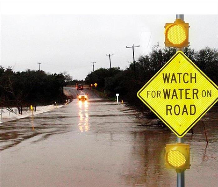 Watch sign on road caused by flooding