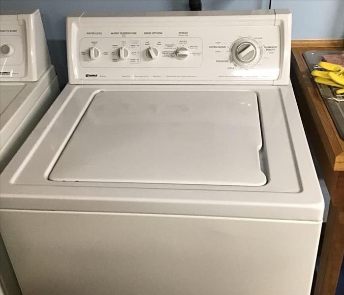 White wash machine sitting next to white dryer
